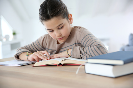 Portrait of 8-year-old girl doing homework